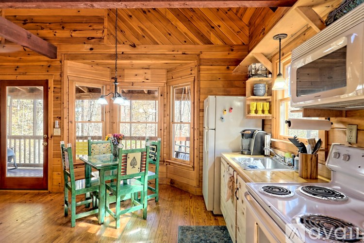 A kitchen with a wooden ceiling and a table with chairs.