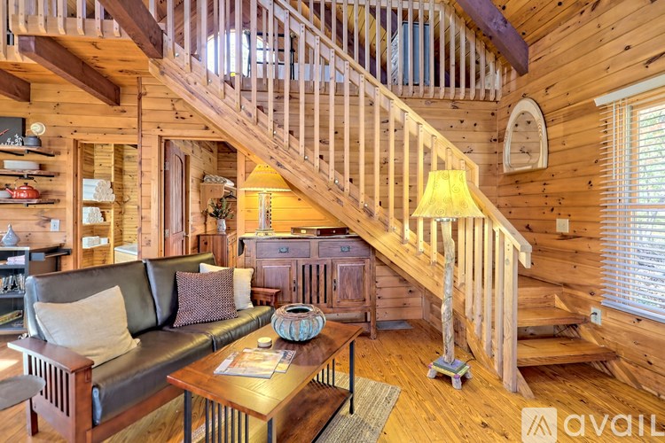 A wooden staircase with a yellow lamp on the landing.