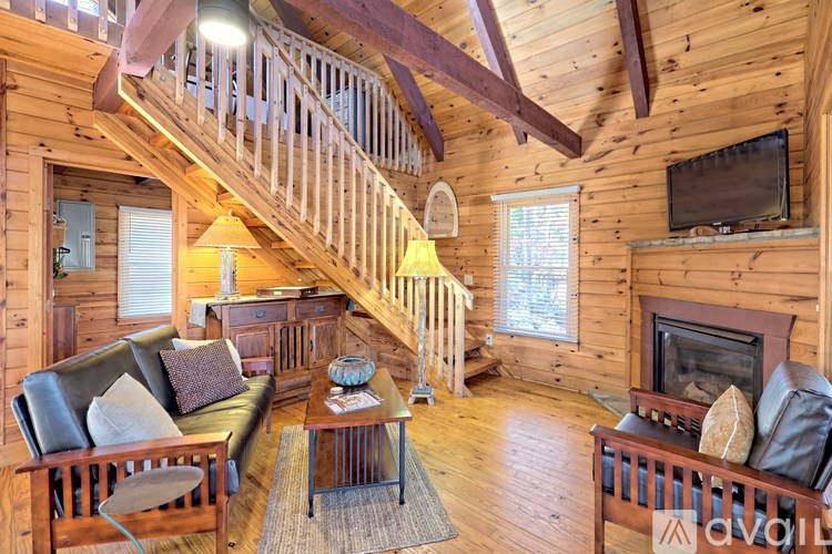 A living room with a couch, a coffee table, and a TV on the wall.