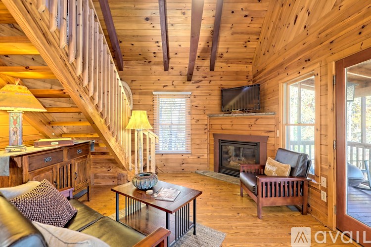 A living room with wooden walls and a staircase.