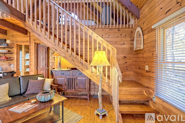 A wooden staircase with a lamp on the side.