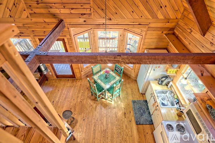A wooden cabin with a table and chairs in the middle.