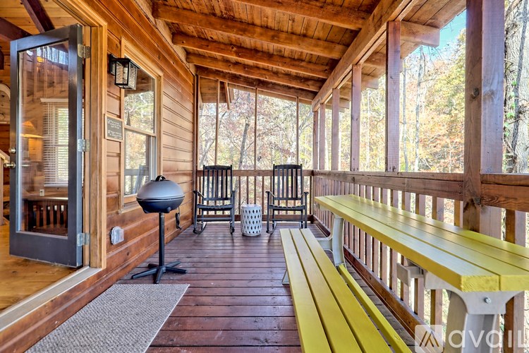 A wooden porch with a bench and a table.