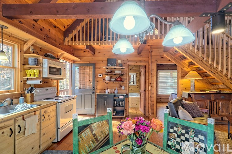 A kitchen with wooden cabinets and a green table with flowers on it.
