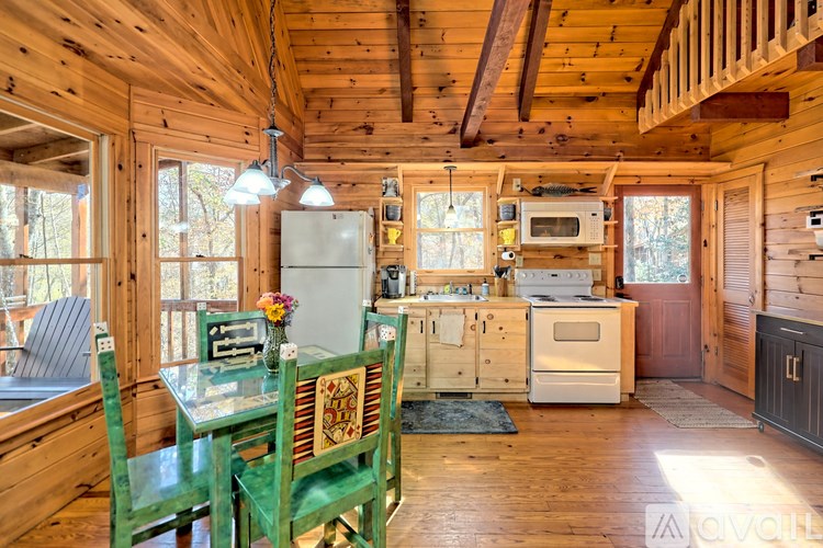 A kitchen with wooden walls and a table with two chairs.