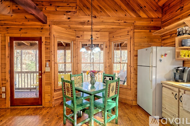 A wooden cabin with a green table and chairs.