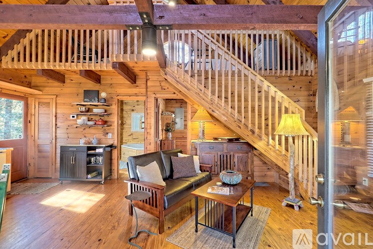 A living room with a couch, a coffee table, and a staircase.