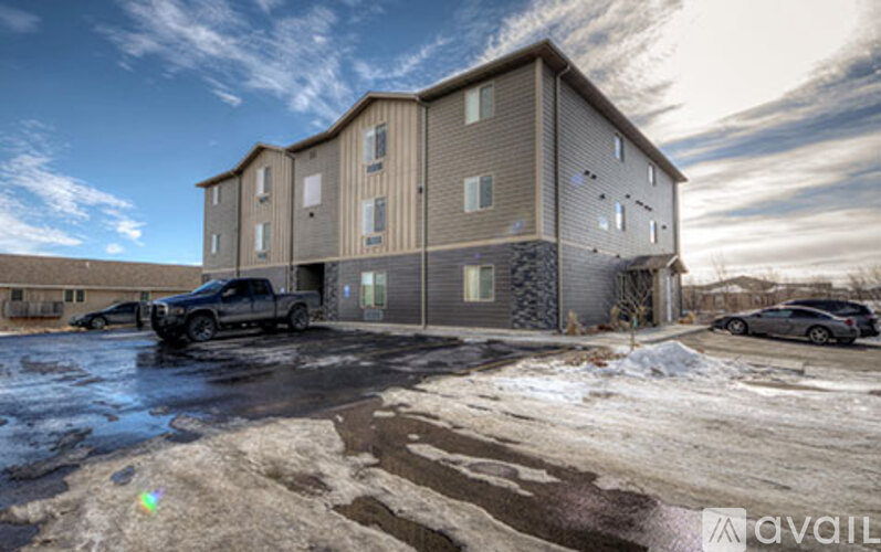 A large apartment complex with a parking lot in front.