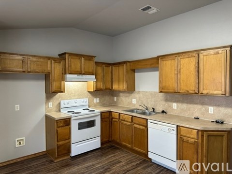A kitchen with wooden cabinets and white appliances.