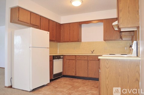 A kitchen with wooden cabinets and a white refrigerator.