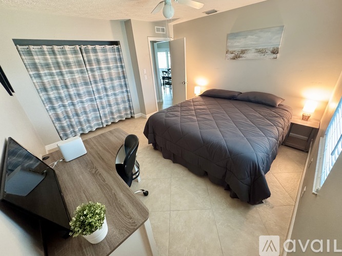 A bedroom with a bed, a television, and a window.