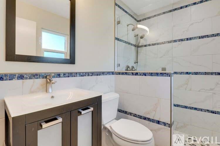 A bathroom with a toilet, sink, and mirror.