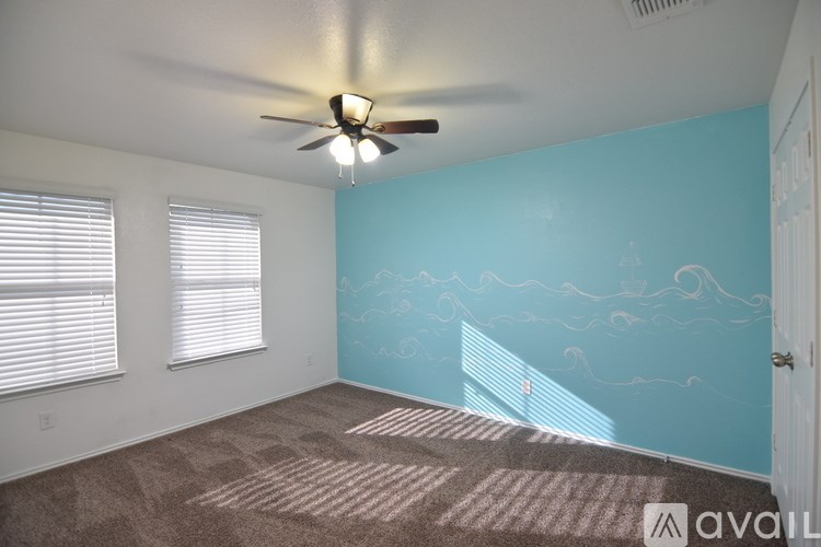 A room with a ceiling fan and carpeted floor.