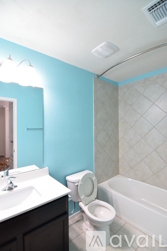 A bathroom with a toilet, sink, and bathtub.