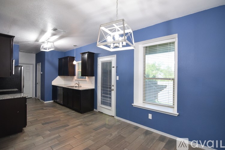A kitchen with blue walls and wooden floors.