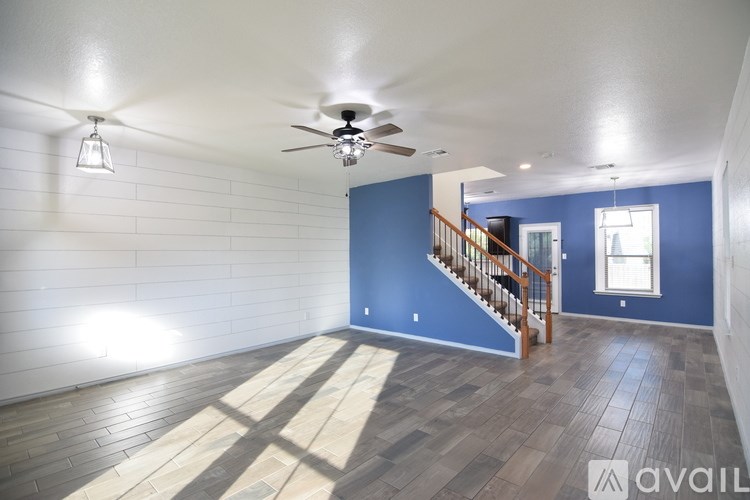 A room with a wooden floor and a staircase.