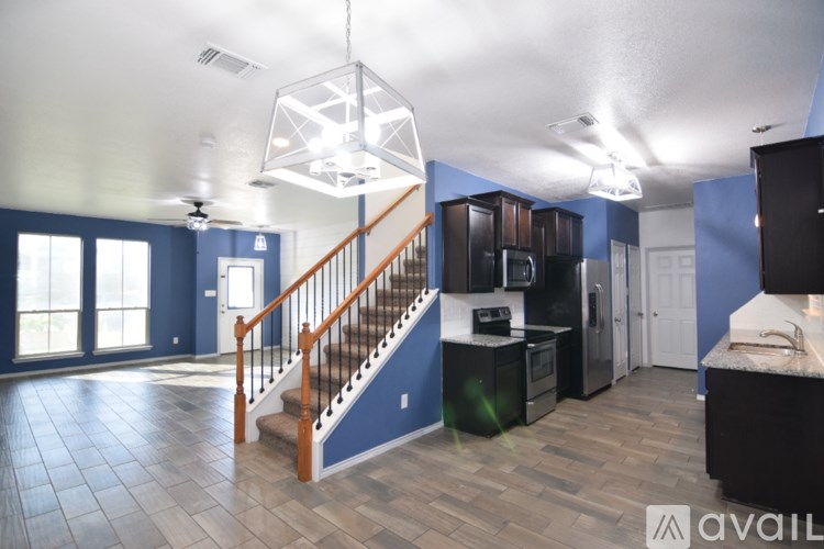 A spacious room with a staircase leading to the upper floor.