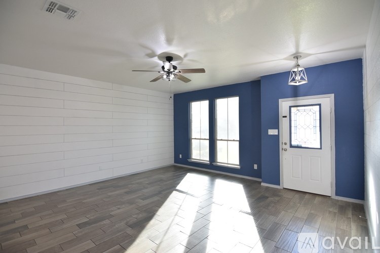 A room with a ceiling fan and a door.