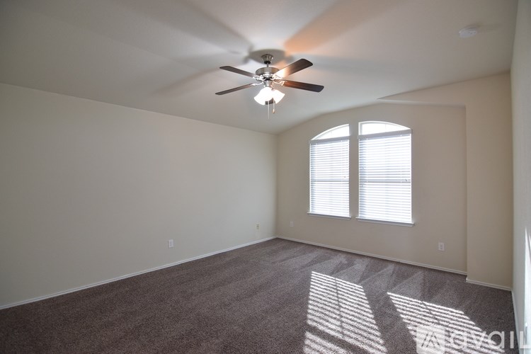 A room with a ceiling fan and carpeted floor.