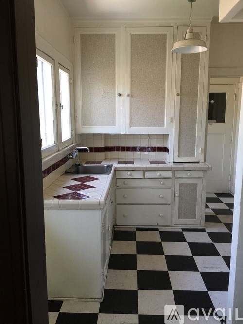 A kitchen with black and white checkered floor.