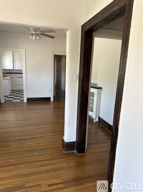 A room with wooden floors and a large mirror on the wall.