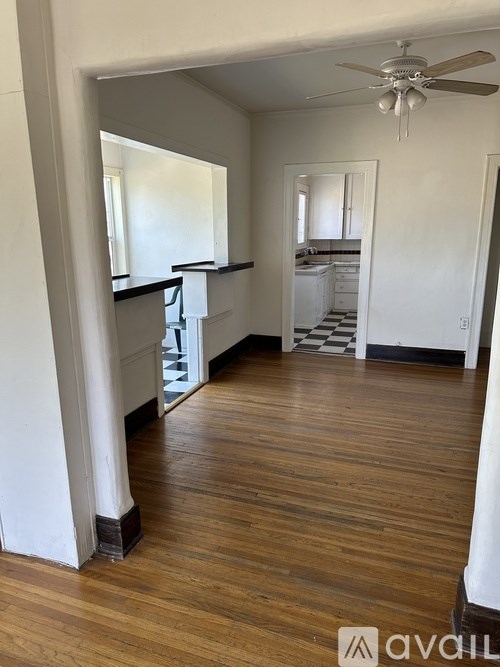 A room with wooden floors and a ceiling fan.