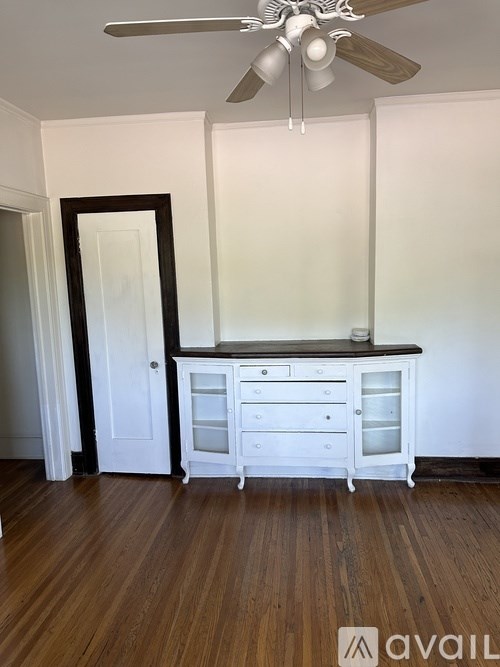 A room with a white cabinet and a ceiling fan.