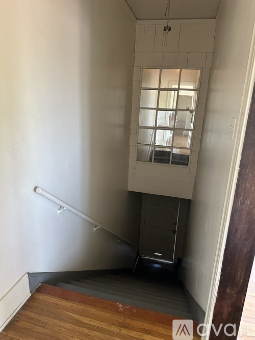 A stairway with a metal railing and wooden steps leading to a second floor.