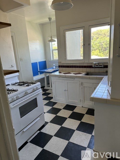 A kitchen with a black and white checkered floor.