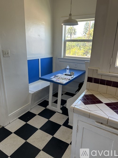 A room with a checkered floor and a table with a blue top.