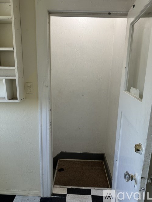 A white door with a black and white checkered floor mat.