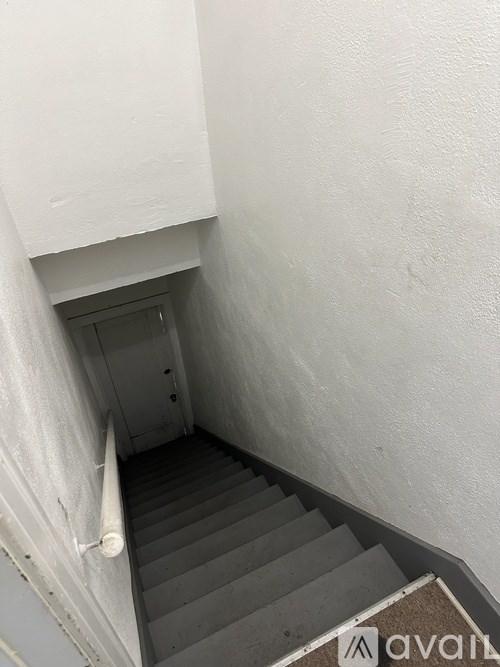 A staircase with a white wall on the side and a brown carpet at the bottom.