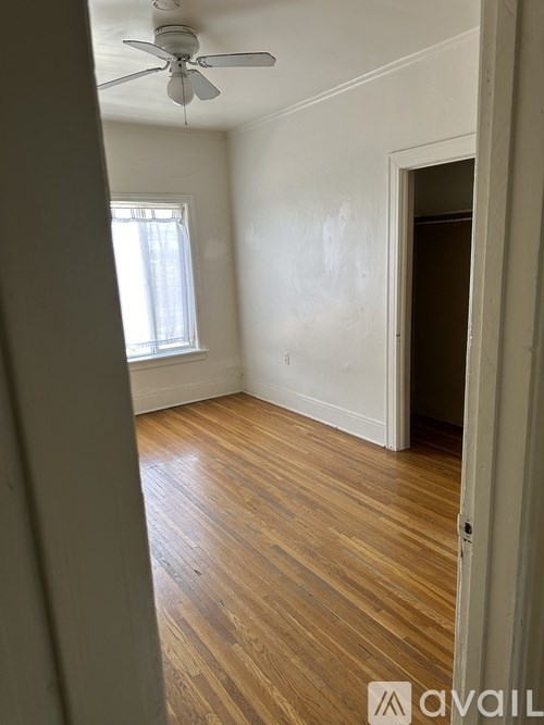 A room with a ceiling fan and wooden flooring.