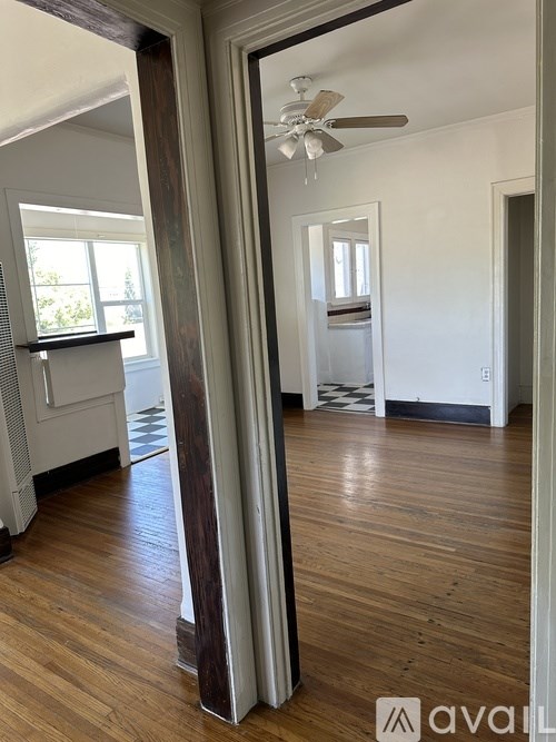 A room with wooden floors and a ceiling fan.