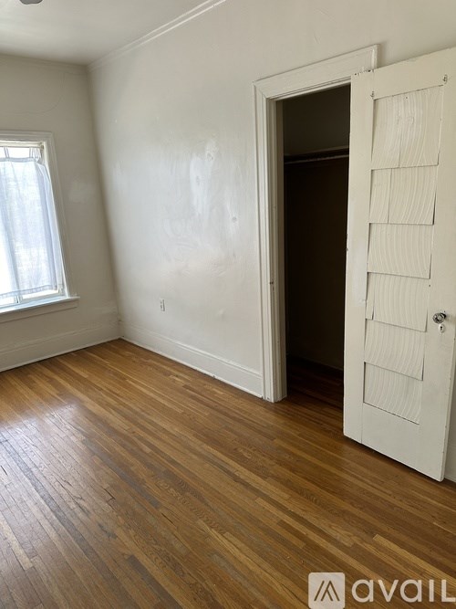 A room with a wooden floor and a white door.