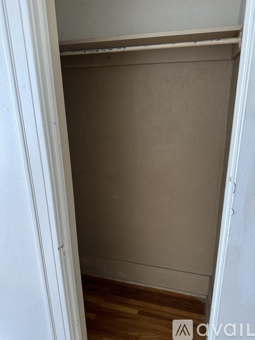 A white door is open to a room with a brown wall.