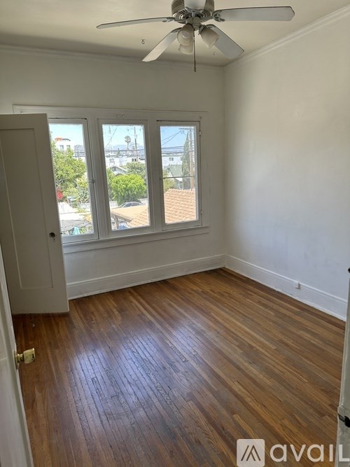 A room with wooden floors and a ceiling fan.