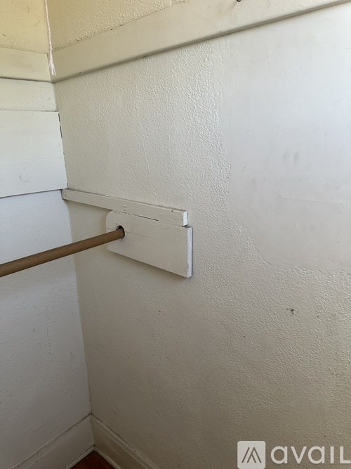 A white wall with a brown bar and a white square object on it.