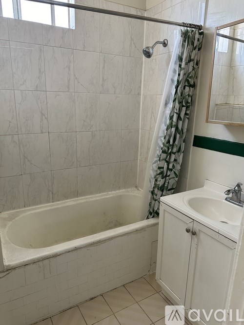 A white bathroom with a tub, sink, and mirror.