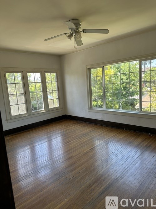 A room with wooden floors and a ceiling fan.