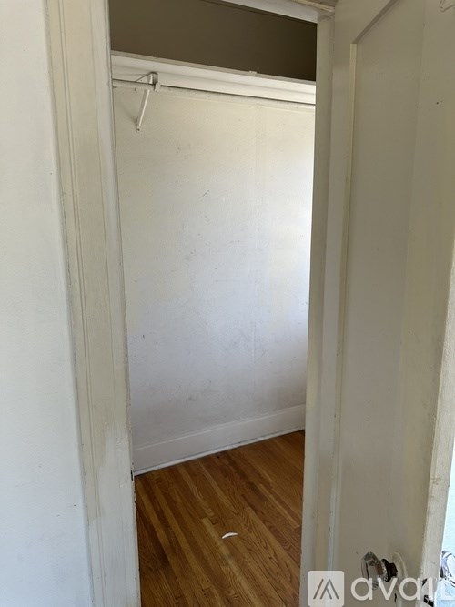 A white door with a coat hanger on the back of it.