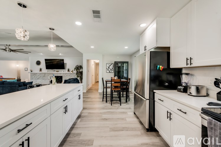 A modern kitchen with white cabinets and a marble countertop.