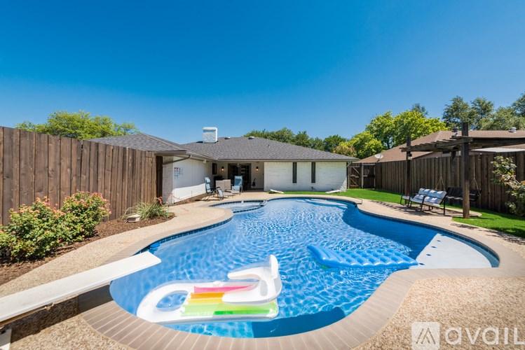 A swimming pool in a backyard with a house in the background.