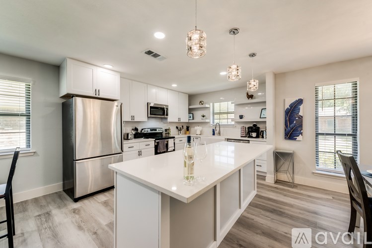 A modern kitchen with a large island and stainless steel appliances.
