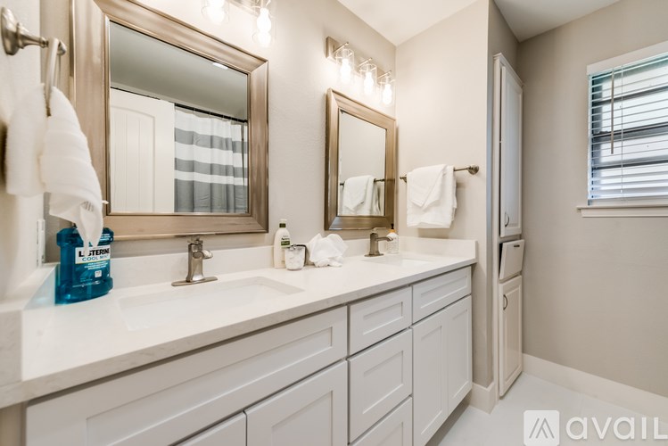 A bathroom with a white countertop and a large mirror above it.
