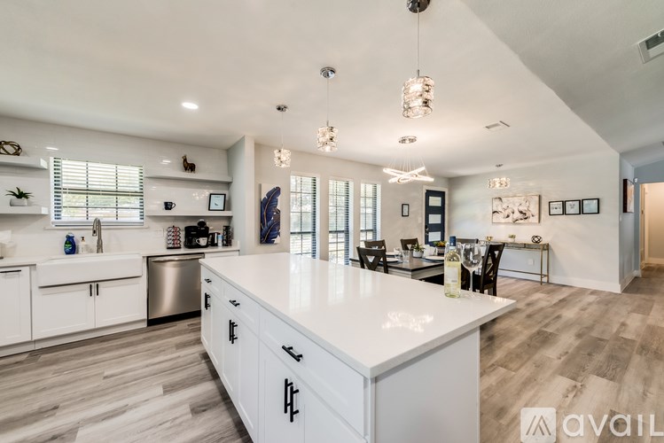 A modern kitchen with white cabinets and a large island.