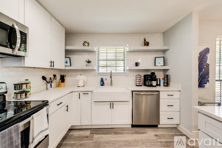 A kitchen with white cabinets and a stainless steel dishwasher.