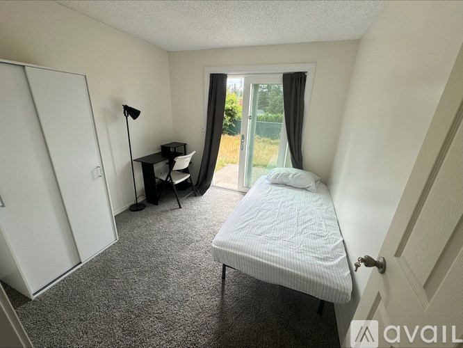 A bedroom with a bed, desk, and chair.