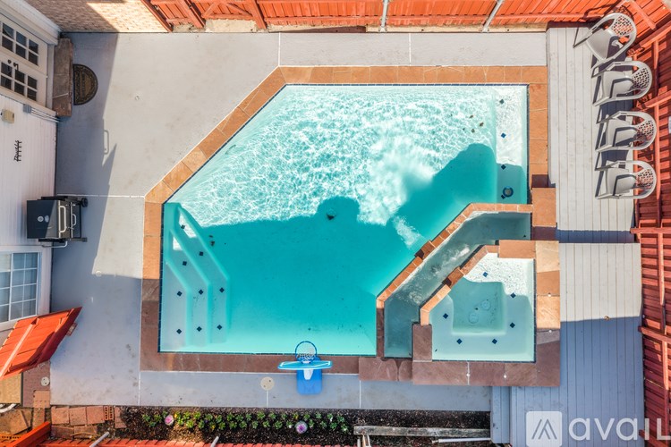 A small pool with a blue handle is surrounded by a white wall.