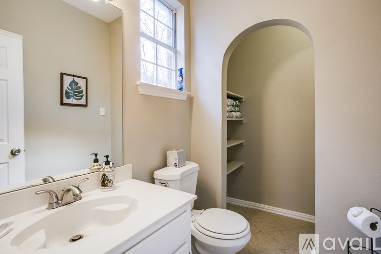 A bathroom with a white sink, toilet, and a mirror.